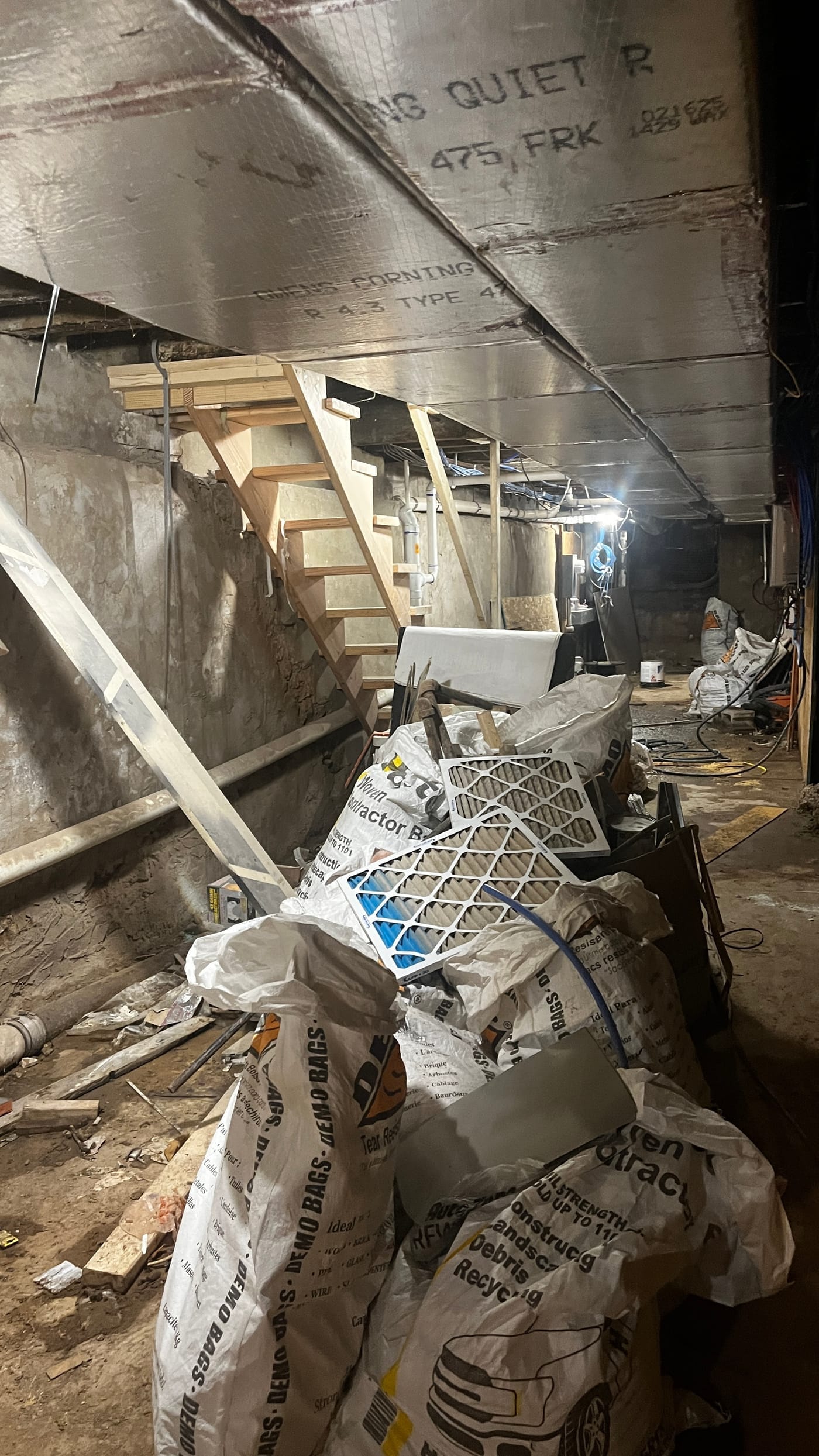 Basement filled with bags of debris and construction materials