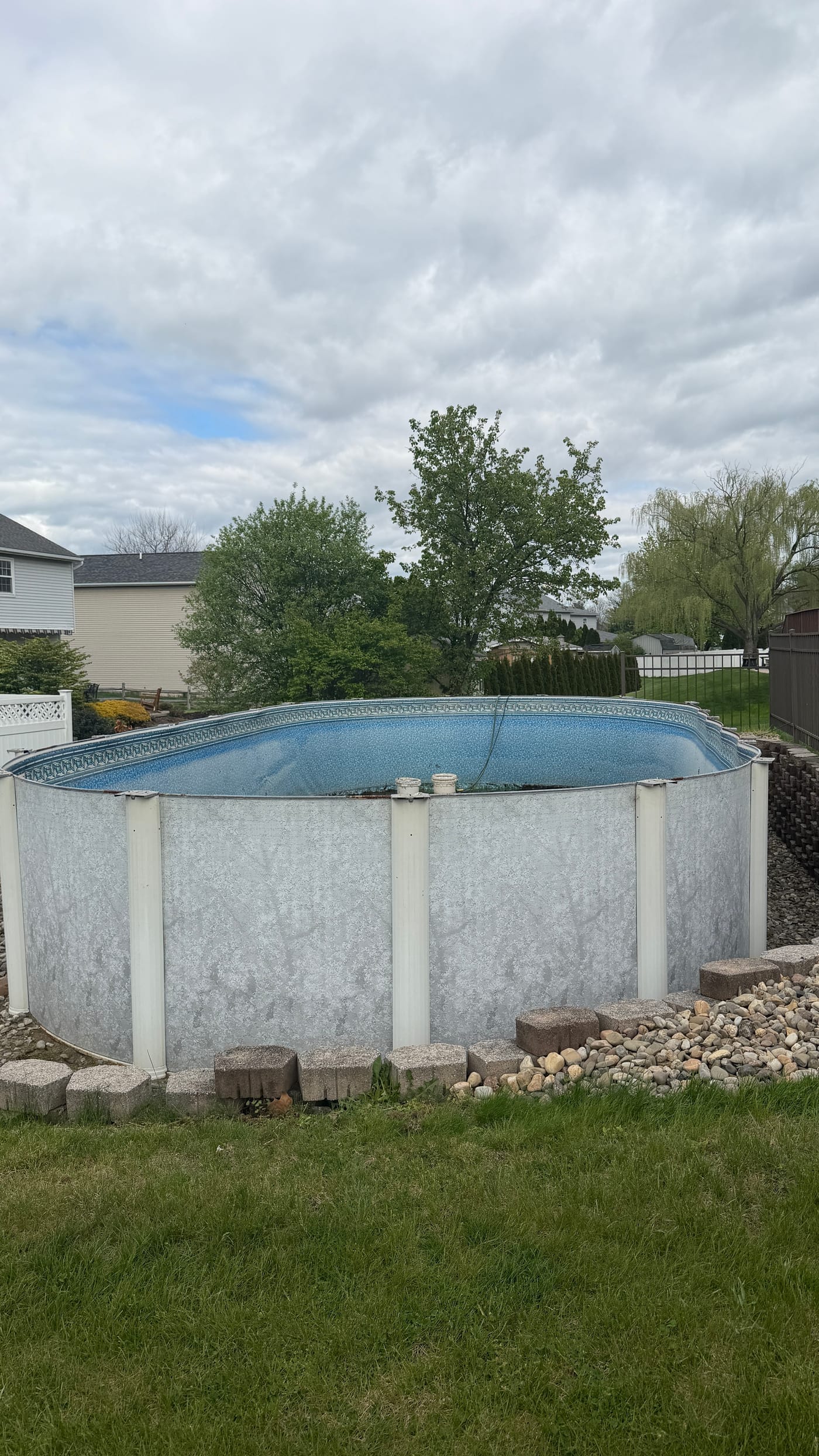 Above-ground pool filled with water in a Berks County backyard before removal