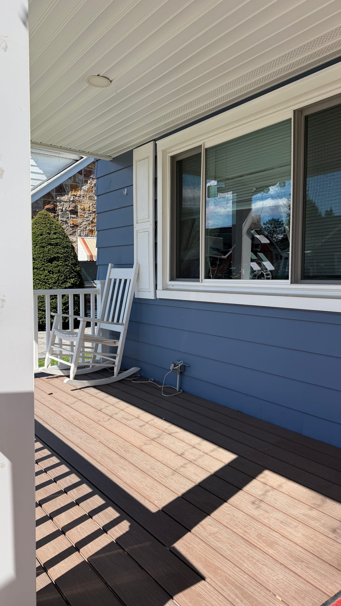 Clean front porch with white rocking chair after furniture removal